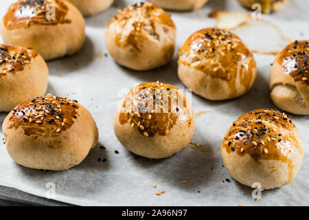 Homemade Turkish Pastries Pogaca with Black Cumin and Sesame Seeds on Baking Paper Sheet with Tray. Traditional Organic Food. Stock Photo