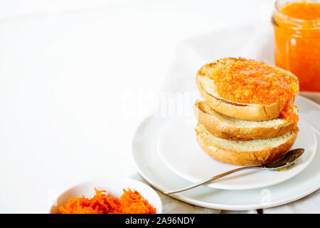 Vegetarian organic sweet carrot jam or marmalade toast topping for breakfast.Healthy vegetable dessert on white background with copy space.Horizontal Stock Photo