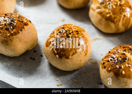 Homemade Turkish Pastries Pogaca with Black Cumin and Sesame Seeds on Baking Paper Sheet with Tray. Traditional Organic Food. Stock Photo