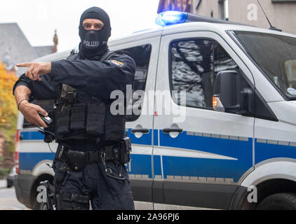 Frankfurt, Germany. 13th Nov 2019. Masked officers of a special police unit secure the evacuation of a suspected terrorist man who had previously been brought before the magistrate at the court centre. The German of Macedonian origin is said to have planned an attack in the Rhine-Main region together with two others. Photo: Boris Roessler/dpa Credit: dpa picture alliance/Alamy Live News Stock Photo