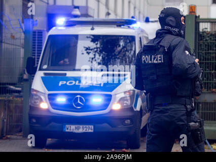 Frankfurt, Germany. 13th Nov 2019. Masked officers of a special police unit secure the evacuation of a suspected terrorist man who had previously been brought before the magistrate at the court centre. The German of Macedonian origin is said to have planned an attack in the Rhine-Main region together with two others. Photo: Boris Roessler/dpa Credit: dpa picture alliance/Alamy Live News Stock Photo