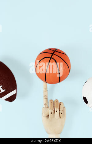 Flat lay of hand holding small basketball ball minimal creative concept. Stock Photo