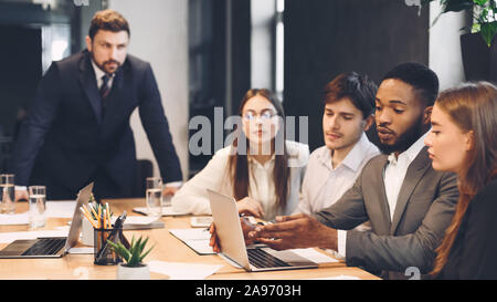 Team meeting process. Colleagues discussing new project in modern office Stock Photo