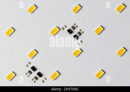 Top view of white aluminum printed circuit board with SMD LEDs and microchips. LED, electronics, lighting and technology concepts. Stock Photo