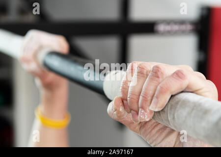 Closeup detail of hands holding a pull-ups bar in a gym. Training, pull-ups, climbing and fitness concepts. Stock Photo