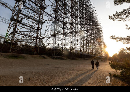 (191113) -- KIEV, Nov. 13, 2019 (Xinhua) -- People visit a deserted radar station near the Chernobyl nuclear power plant in Ukraine, Nov. 12, 2019. The Chernobyl nuclear power plant, some 110 km north of Kiev, witnessed one of the worst nuclear accidents in human history on April 26, 1986. As radiation levels decreased, the 30-square-km area around the plant was officially opened to tourists in 2010. Guided tours to the plant were launched in 2018. (Xinhua/Bai Xueqi) Stock Photo