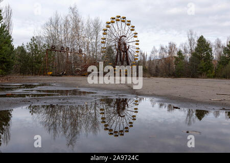 (191113) -- KIEV, Nov. 13, 2019 (Xinhua) -- A ferris wheel is seen near the Chernobyl nuclear power plant in Ukraine, Nov. 12, 2019. The Chernobyl nuclear power plant, some 110 km north of Kiev, witnessed one of the worst nuclear accidents in human history on April 26, 1986. As radiation levels decreased, the 30-square-km area around the plant was officially opened to tourists in 2010. Guided tours to the plant were launched in 2018. (Xinhua/Bai Xueqi) Stock Photo