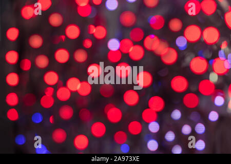 Red blue and purple lights blurred background. Glowing Christmas lights. Abstract colorful New Year backdrop. Large size image. Stock Photo