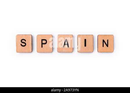 The word SPAIN, spelt with wooden letter tiles, over a white background. Stock Photo