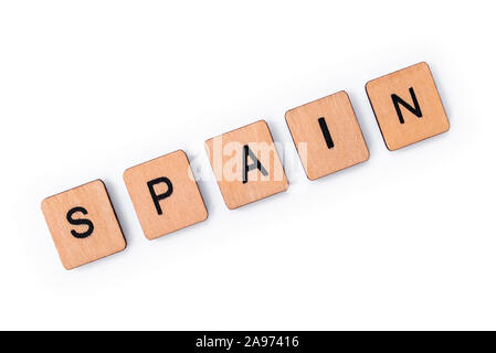 The word SPAIN, spelt with wooden letter tiles, over a white background. Stock Photo