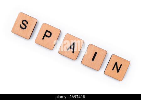 The word SPAIN, spelt with wooden letter tiles, over a white background. Stock Photo