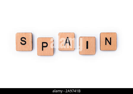 The word SPAIN, spelt with wooden letter tiles, over a white background. Stock Photo