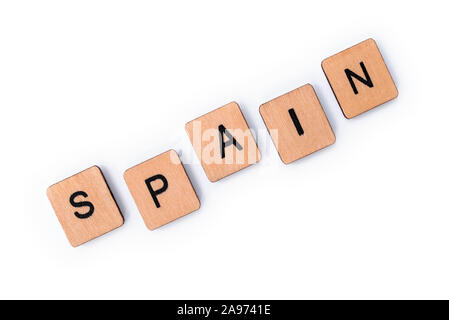 The word SPAIN, spelt with wooden letter tiles, over a white background. Stock Photo