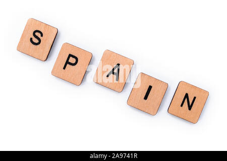 The word SPAIN, spelt with wooden letter tiles, over a white background. Stock Photo