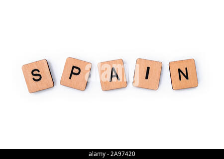 The word SPAIN, spelt with wooden letter tiles, over a white background. Stock Photo