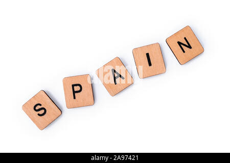 The word SPAIN, spelt with wooden letter tiles, over a white background. Stock Photo