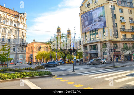 Budapest, Hungary - Nov 6, 2019: Road and zebra crossing in the center of the Hungarian city. Dohany Street Synagogue, the largest synagogue in Europe in the background. Historical buildings. Stock Photo