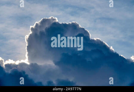 Sun behind a cumulonimbus calvus cloud Stock Photo