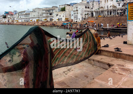 Pushkar, Rajasthan, India: two Indian women blow wet saris on the shores (ghat) of the holy Pushkar lake Stock Photo