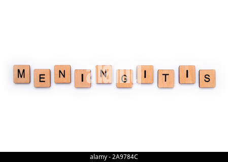 The word MENINGITIS, spelt with wooden letter tiles over a white background. Meningitis is an infection of the protective membranes that surround the Stock Photo