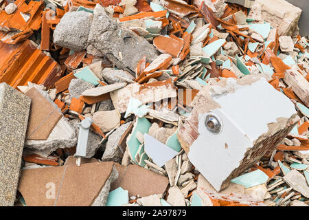 Construction waste dump detail. Rubble pile of broken bricks, tiles and concrete. Building debris closeup. Pieces of damaged floor and masonry. Renew. Stock Photo