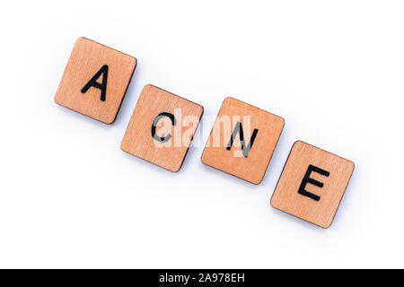 The word ACNE, spelt with wooden letter tiles over a white 