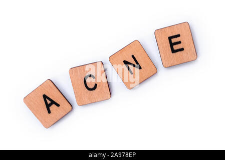 The word ACNE, spelt with wooden letter tiles over a white 