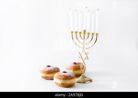 Jewish Hanukkah menorah and sufganiyot donuts isolated on white background. Copy space Stock Photo