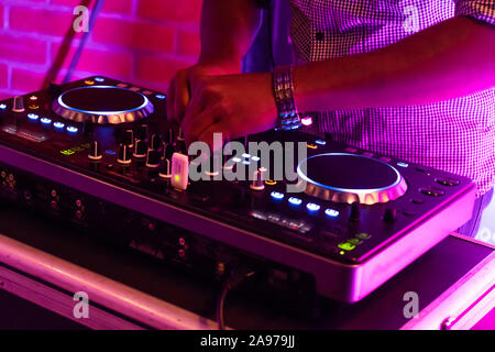 DJ playing music.Midi controller turntable.New digital technology for mixing audio tracks.Sound mixer with turntables.Disc jockey mix music at party Stock Photo