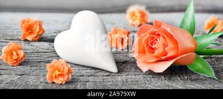 Rose and heart against wooden background Stock Photo