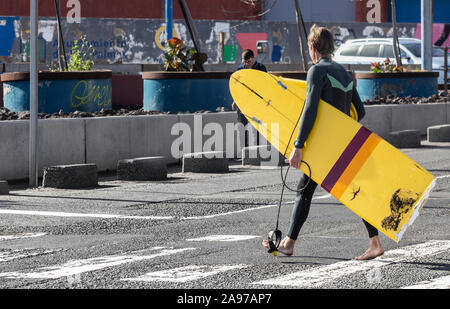 Surfer carrying broken surfboard Stock Photo