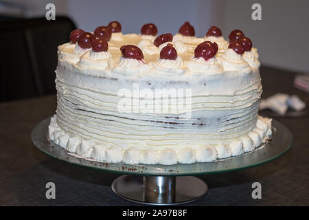 Authentic Black Forest Cake (Schwarzwalder kirsch cake) decorated with whipped cream and cherries on a plate Stock Photo
