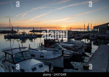 Boats moored in Cala Bona Marina Majorca with a beautiful Sunrise full of vibrant and golden colors. Stock Photo