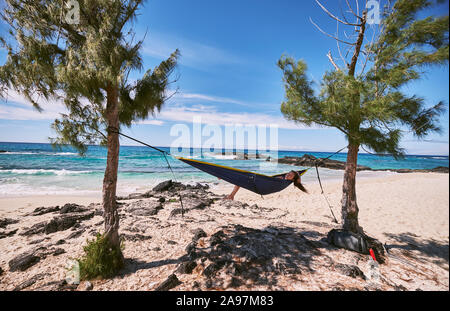 A woman relaxing in her hammock on Makalawena Beach, Hawaii Stock Photo