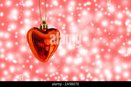 Red Christmas heart with blurry bokeh snow flake and light background. Close up image with copy space.. Stock Photo
