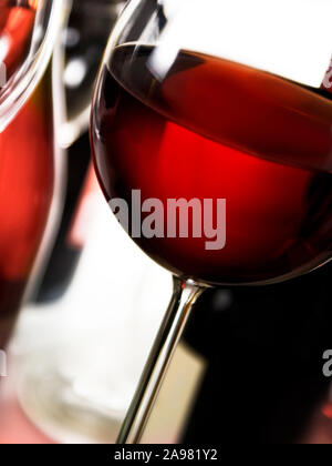 Red wine glass and bottles against white background Stock Photo