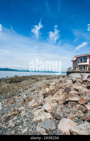 Part of a beach house with the rocky shore of Alki Beach in West Seattle, Washington. Stock Photo