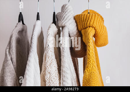 Warm knitted sweaters on the hangers. Stock Photo