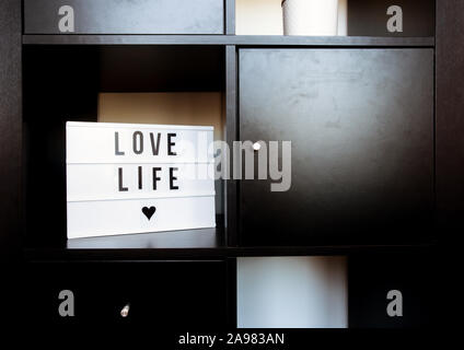 Sign, Love life on black wooden shelf, modern decoration in retro home clean interior Stock Photo