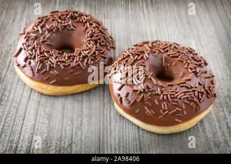 Two Donuts against wooden background Stock Photo