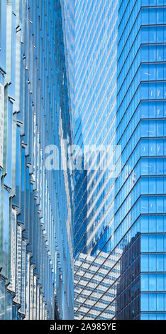 Modern buildings reflected in glass facades, abstract architectural background. Stock Photo