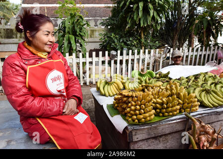 Saleswoman in front of her fruit stall, fresh food market, Luang Prabang, Laos Stock Photo