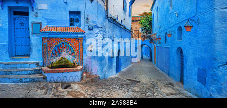 Colorful fountain with drinking water on house wall in famous blue town of Chefchaouen. Morocco, North Africa Stock Photo