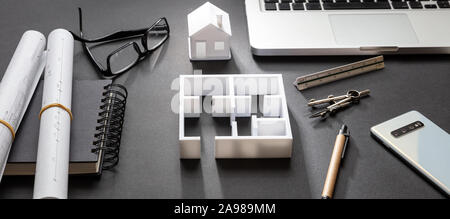 Architect engineer office desk. Blueprint plans and house model, Residential building project in black and white, banner Stock Photo