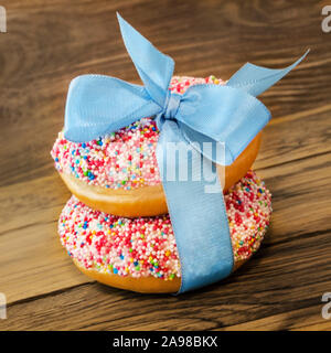 Two Donuts against wooden background Stock Photo