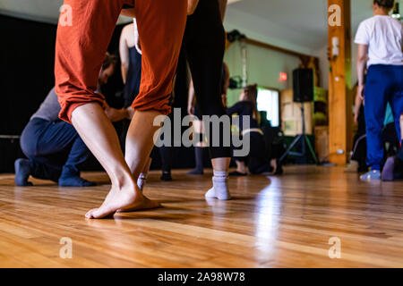 Selective focus of mixed generations people practicing yoga techniques and helping each other out with body positions Stock Photo