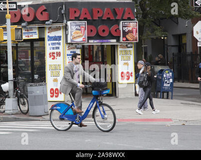 Man rides a bicycle along 6th Avenue at West 4th Street in the Greenwich Village  neighborhood in New York City. Stock Photo