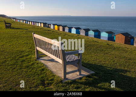 Benches and beach huts along the seafront in the coastal town of Tankerton in Kent, UK. Stock Photo