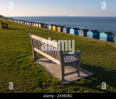 Benches and beach huts along the seafront in the coastal town of Tankerton in Kent, UK. Stock Photo