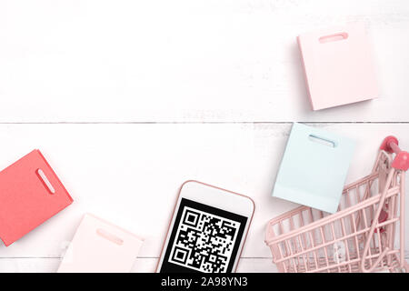 Abstract online shopping,mobile payment with QR code design concept element,colorful cart,paper bag on wooden table background,top view,flat lay Stock Photo